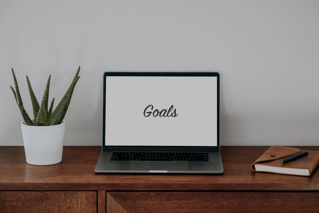 Computer with the word "goals" describing the objectives of content marketing and how to achieve them